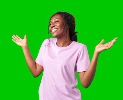 A young woman in casual attire smiles playfully with hands raised in a questioning gesture against a bright green background close up