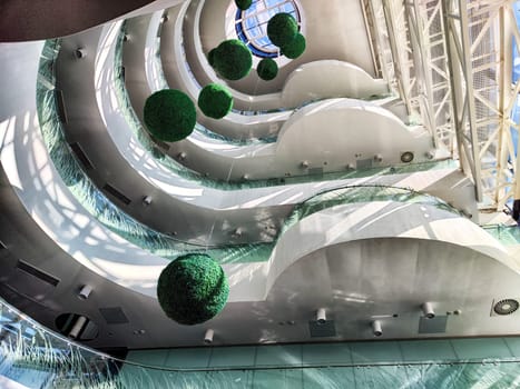The unique interior design showcases green spherical decorations and smooth curves in a contemporary structure, inviting exploration.