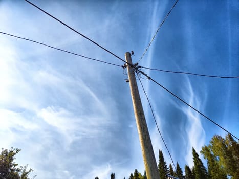 Old pole with wires against the sky. Electric transmission line, Eco-friendly energy