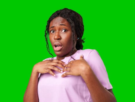 Surprised young woman against a vibrant green background expressing astonishment or shock close up