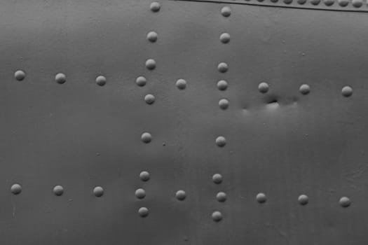 The fuselage skin of an old military aircraft with rivets. Close-Up of Gray Metal. Metal abstract background.