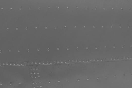 A fragment of a military airplane fuselage. Close-Up of Gray Metal. Metal abstract background.
