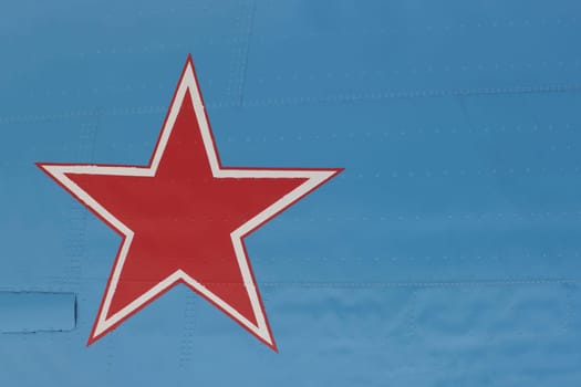 An army star with a white border on a green background of metal plating with rivets.