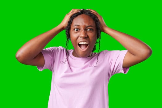 Woman expressing surprise and excitement on a bright green background in studio