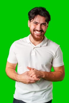 A smiling young man with a beard poses against a bright green background close up