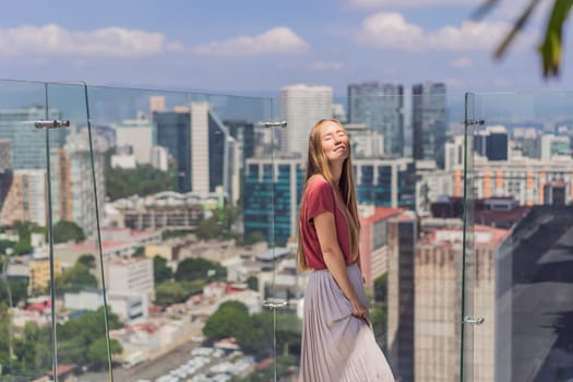 Female tourist or businesswoman standing on a skyscraper rooftop with a panoramic view of Mexico City. Travel or international business in Mexico concept.
