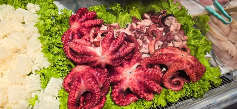 Fresh octopus arranged on a bed of lettuce at a seafood market. Vibrant colors highlight the octopus's texture, creating an enticing display for seafood enthusiasts, good for recipe book and content creation