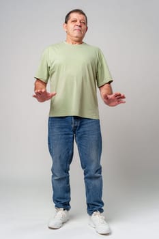 An older man standing confidently in casual attire, wearing a green shirt close up