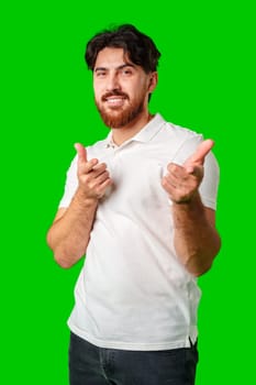 Smiling man gestures playfully with finger guns against a vibrant green background close up