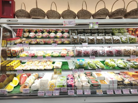 A well stocked fruit section in a grocery store, displaying a variety of colorful and fresh fruits like apples, oranges, and pears.