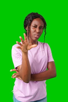 Young woman with curly hair shows a skeptical expression against a bright green background in studio