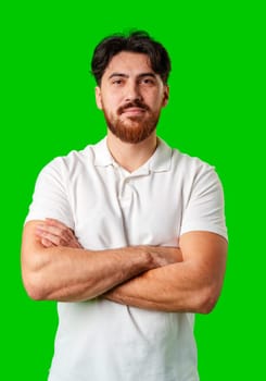 A man with a serious expression stands against a vibrant green background in studio