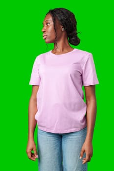 A young woman in a light purple shirt stands against a bright green background in studio