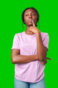 Thoughtful woman pondering in front of a bright green background during a casual moment close up