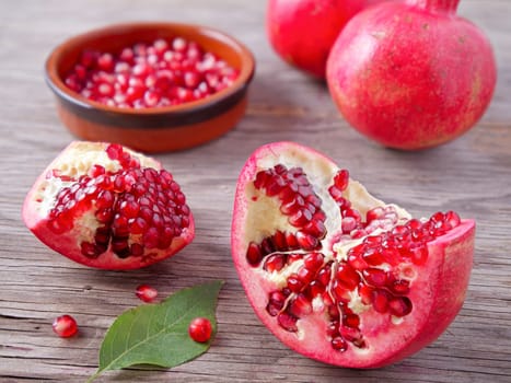 A close up vivid photo of  opened pomegranates and their seeds.
