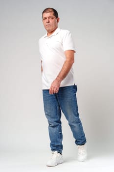 A middle-aged man poses confidently in casual attire against a neutral background in studio