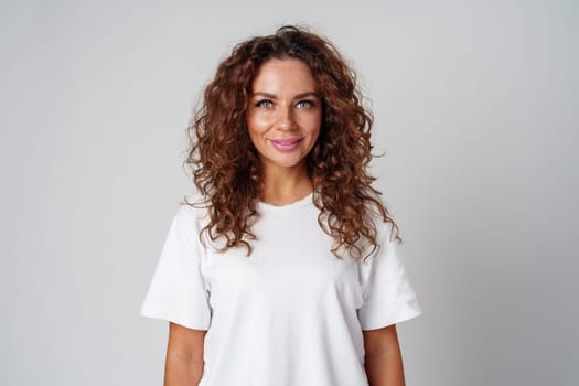 Young woman posing confidently in casual attire against a neutral backdrop close up