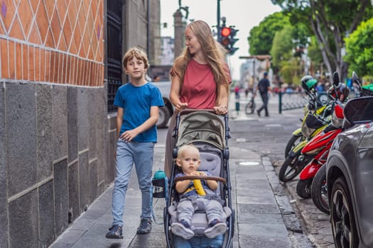 Mother tourist with her toddler and teenage sons walking through the colorful colonial streets of Puebla, Mexico. Travel, cultural exploration, and vibrant architecture concept.
