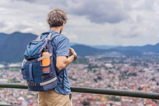 Male tourist in front of the panoramic view of Orizaba from Cerro del Borrego, Mexico. Travel, scenic landscape, and adventure concept.