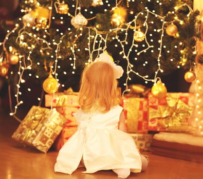 happy child dreams near christmas tree with gifts boxes at home