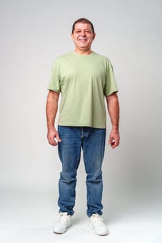 Smiling middle-aged man with short hair in a light green shirt against a simple backdrop close up