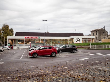 Cremona, Lombardy, Italy October 15th 2024 Modern eurospar supermarket building with parking lot and cars parked in front on a cloudy autumn day