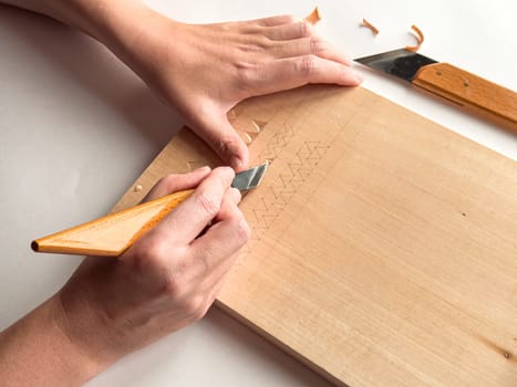 Woodworking craftsmanship. Precision carving techniques on wooden surface.