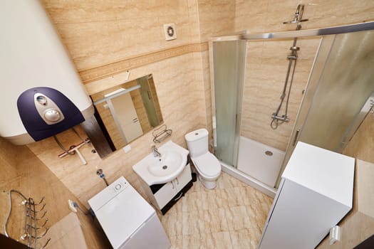 Shower cabin in the bathroom next to the toilet, washbasin, washing machine and boiler. Top view. High quality photo