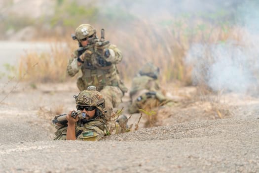 Group of military or soldiers hold the gun and point to the front and ready to fight with enemy during outdoor practice.