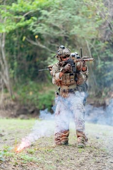 Vertical image of two of militaries or soldiers stand in battlefield near the river with point gun to different direction during outdoor practice.
