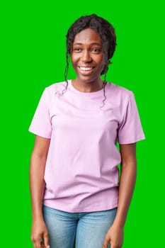 Young woman smiling joyfully in a pink shirt against a vibrant green background in a cheerful atmosphere close up