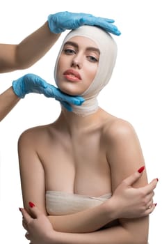 Girl her head and neck bandaged at plastic surgeon medical examination isolated shot on white background