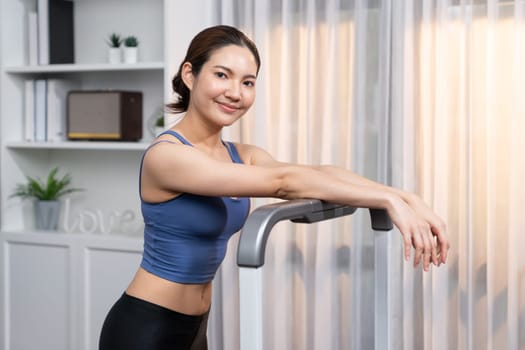 Asian woman in sportswear portrait, smiling and posing cheerful gesture. Home workout training or exercise fitness lifestyle. Attractive girl engage in her pursuit of healthy lifestyle. Vigorous