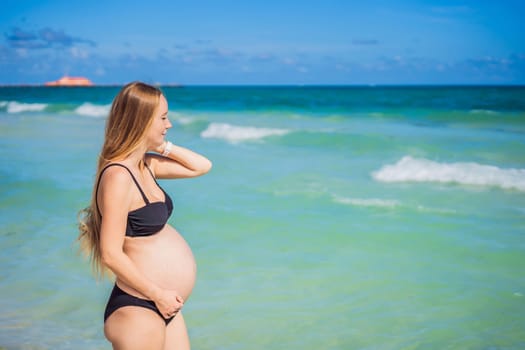 Radiant pregnant woman in a swimsuit, amid the stunning backdrop of a turquoise sea. Serene beauty of maternity by the shore.