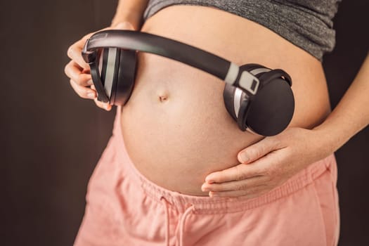 Melodies in the womb: Headphones placed on a pregnant belly, bonding through music, a heartwarming connection between mother and baby.