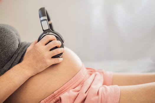 Melodies in the womb: Headphones placed on a pregnant belly, bonding through music, a heartwarming connection between mother and baby.