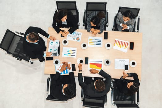 Business people group meeting shot from top view in office . Profession businesswomen, businessmen and office workers working in team conference with project planning document on meeting table . Jivy