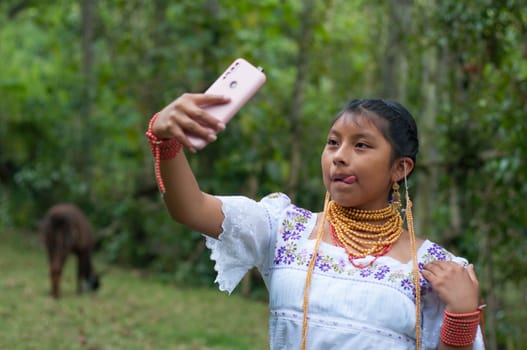 indigenous teenager from latin america sending a photo to her lover from the jungle of Ecuador with her yama . High quality photo