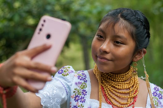 native girl from ecuador taking a selfi with a mobile smartphone with a beautiful smile and traditional dress and jewelry. High quality photo