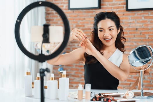 Asian Woman influencer shoot live streaming vlog video review makeup uttermost social media or blog. Happy young girl with cosmetics studio lighting for marketing recording session broadcasting online