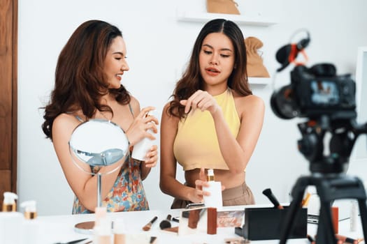 Asian Woman influencer shoot live streaming vlog video review makeup uttermost social media or blog. Happy young girl with cosmetics studio lighting for marketing recording session broadcasting online