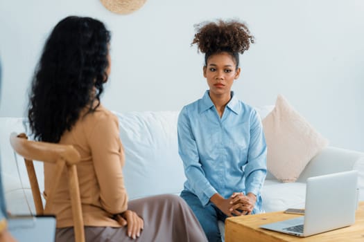 Sad PTSD woman patient in crucial therapy for mental health with psychologist, depression or grief after life failure. Frustrated trauma young woman talking to a psychologist about emotion in clinic