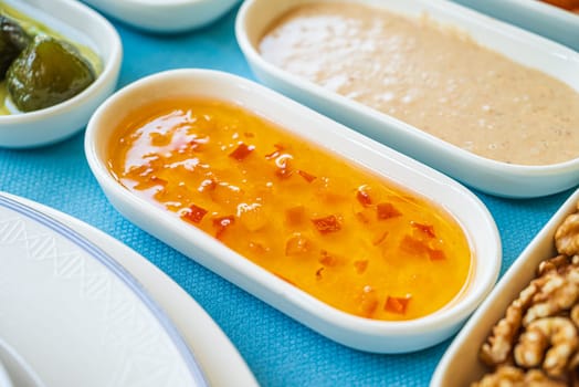 Orange jam in a white porcelain bowl on the breakfast table