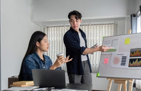 Young businessman explains work plan in meeting to teammates in conference room..