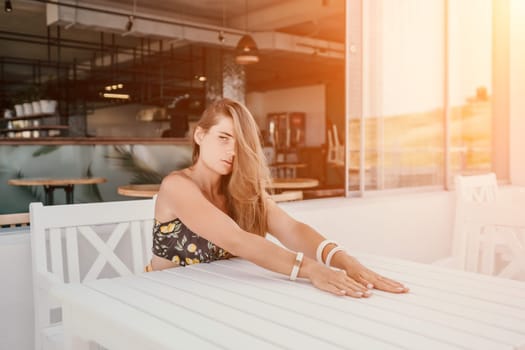 Happy woman portrait in cafe. Boho chic fashion style. Outdoor photo of young happy woman with long hair, sunny weather outdoors sitting in modern cafe