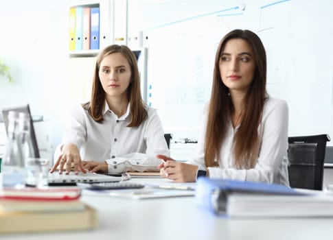 Portrait pretty business lady looking at camera with calmness of smart businesswoman sitting indoors and discussing important topic. Accounting office concept