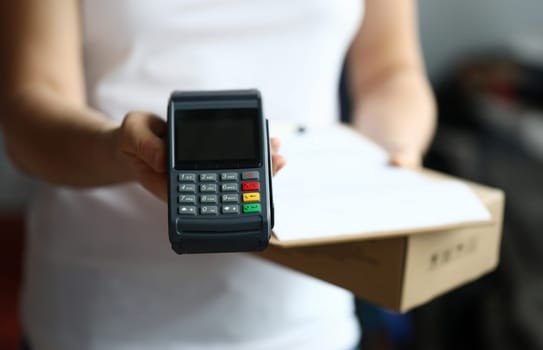 Close-up of delivery service and male holding cashier machine for fast payment. Nfc technology counter. Person with clipboard for sign. Client make transaction pay bill on terminal