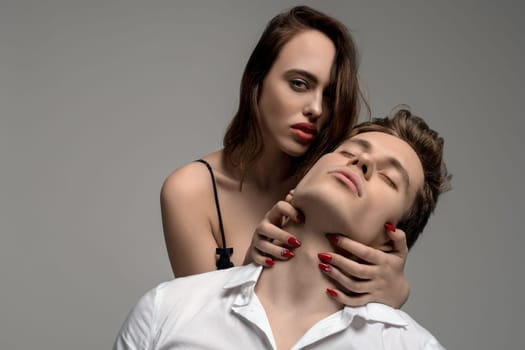 Sexy young girl in underwear and a handsome man in white shirt portrait on gray background