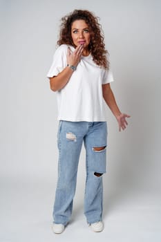 Surprised woman expressing strong emotions with wide eyes and raised hands, studio setting close up
