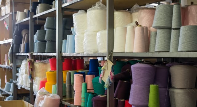 Spools with different color thread on shelves at knitting shop view
